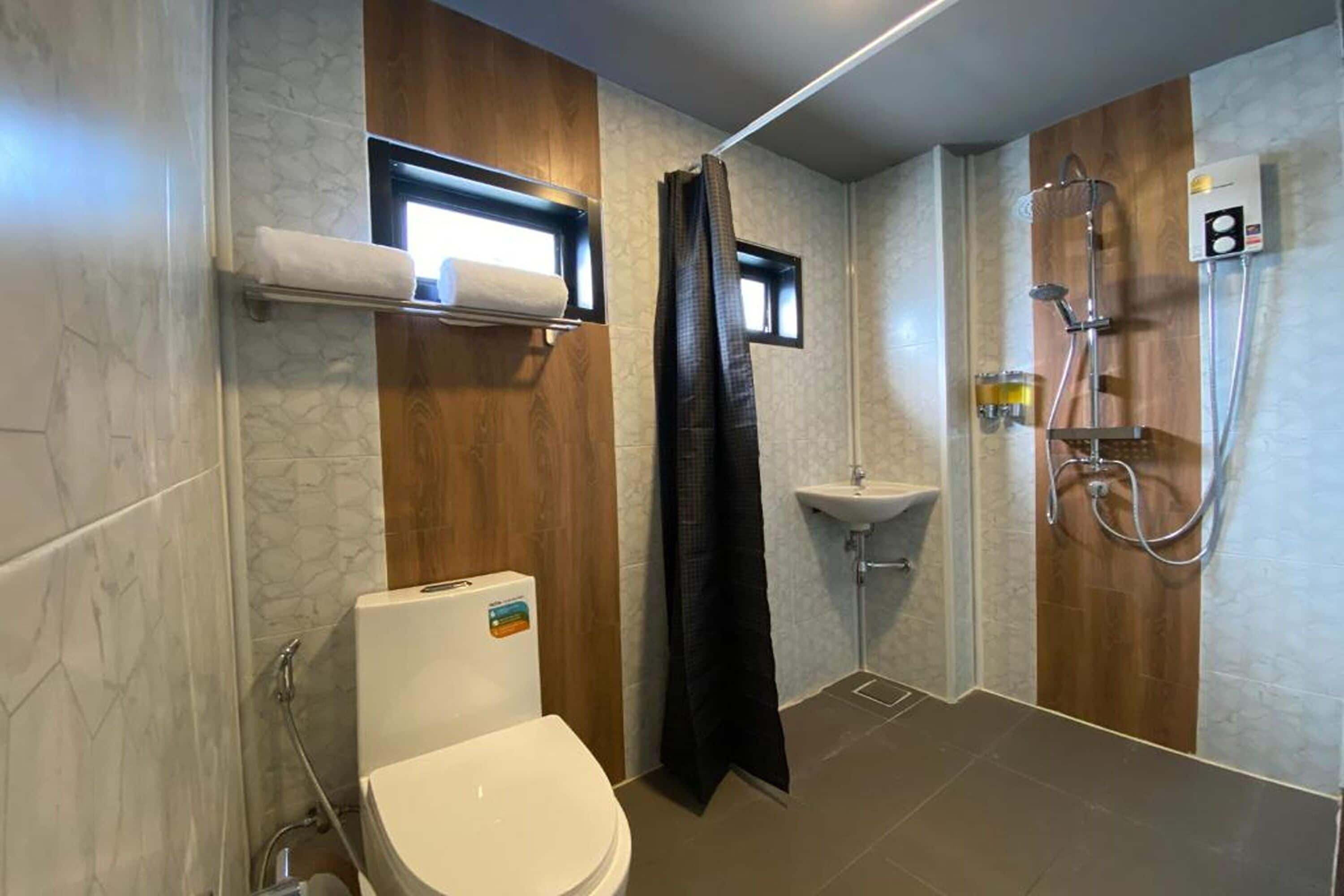Et moderne badeværelse med toilet, vask og brusebad.