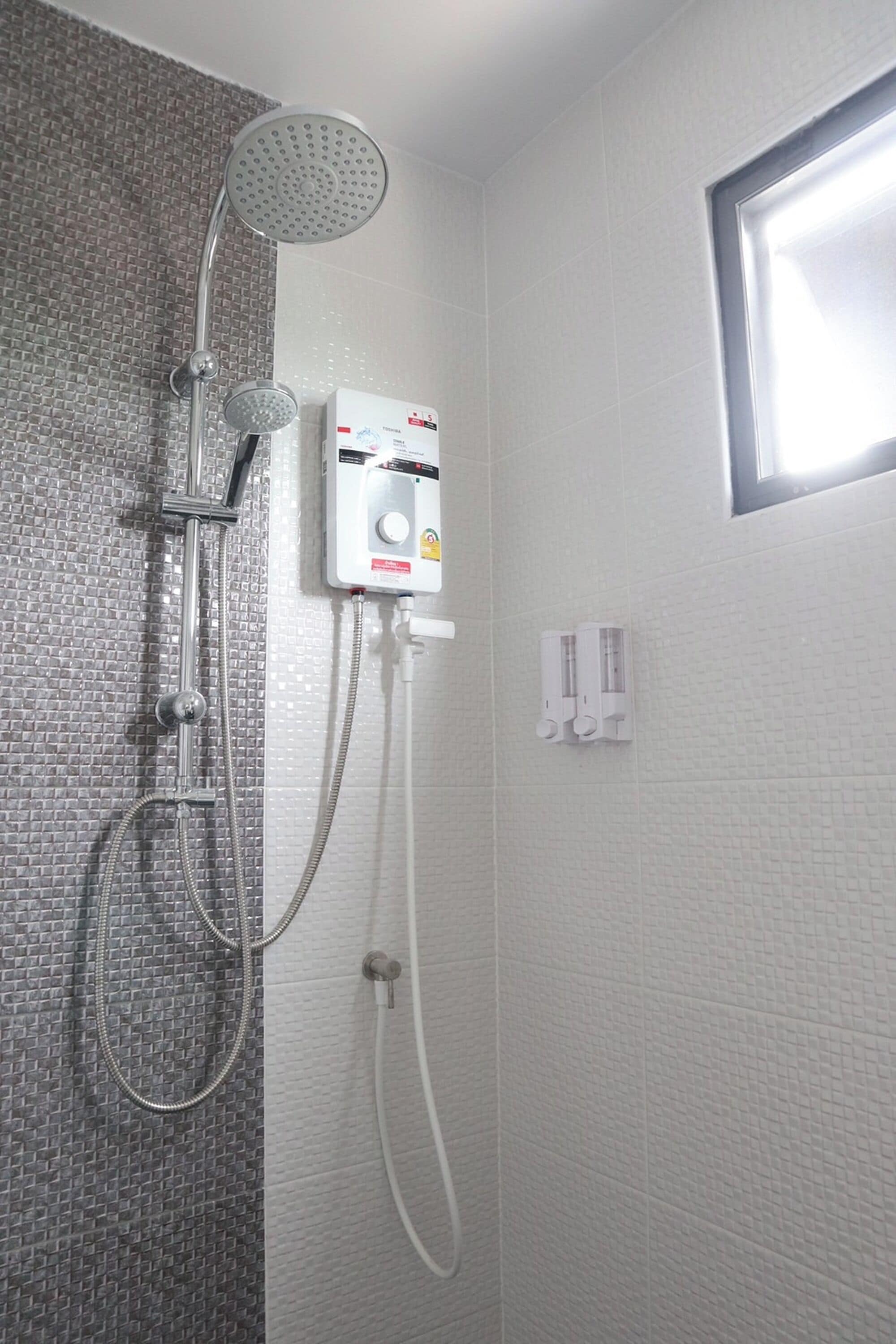 Ducha con cabezal de ducha de mano y grifo empotrado, panel de control y ventana.