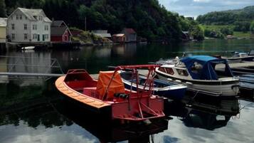 En stilla sjö med förtöjda båtar, omgiven av hus och grönområden.