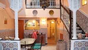 Un intérieur de style traditionnel comprenant un coin repas, un escalier et une cuisine.