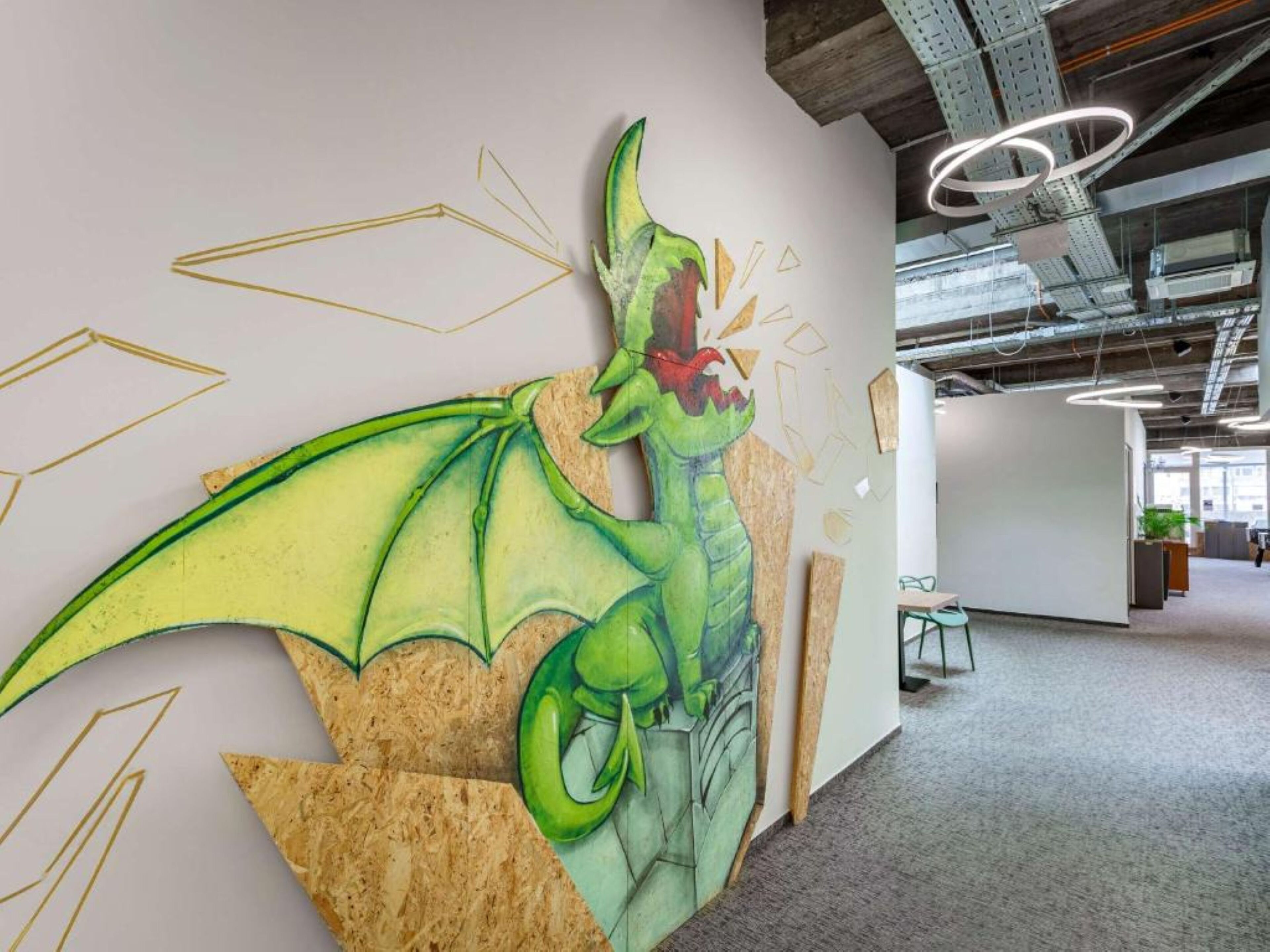 A modern office space with a large, colorful dragon mural on the wall.