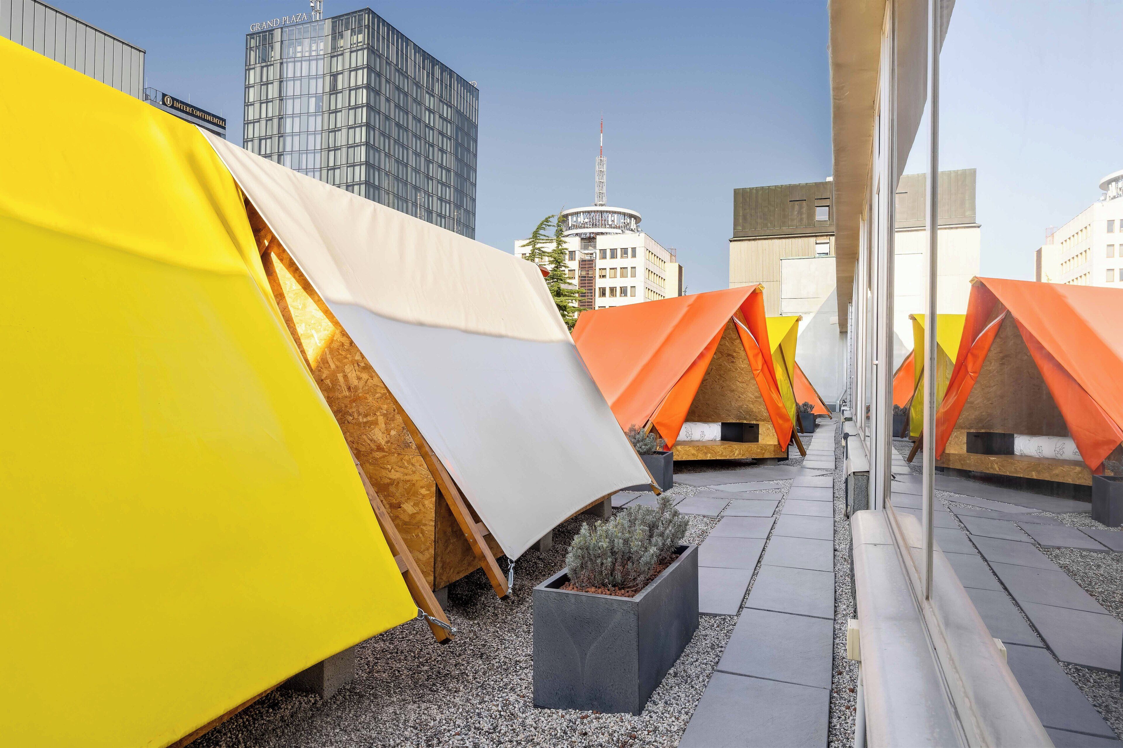 A row of colorful tents with a cityscape in the background.