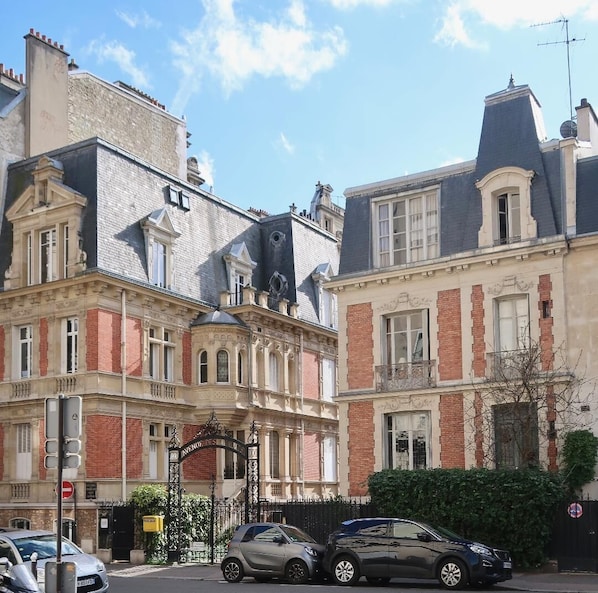 A street view of a row of historic buildings with classic architecture, including ornate facades and large windows.