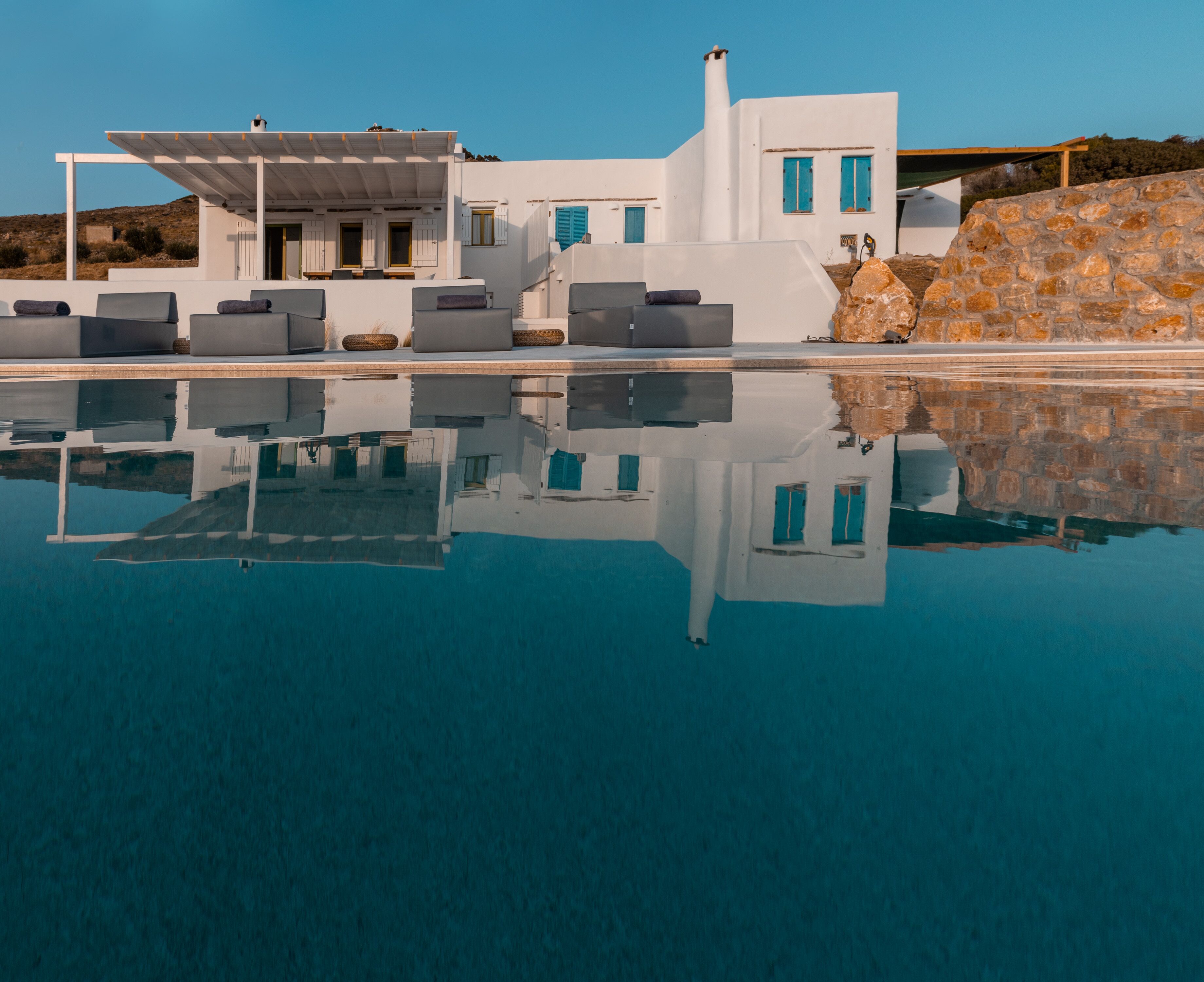 A modern white building with a pool in front.