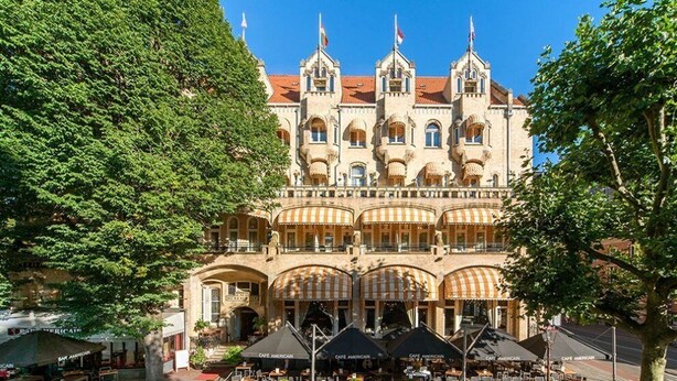 Ein historisches Gebäude mit Innenhof, mehreren Balkonen und Außenbereichen zum Verweilen.