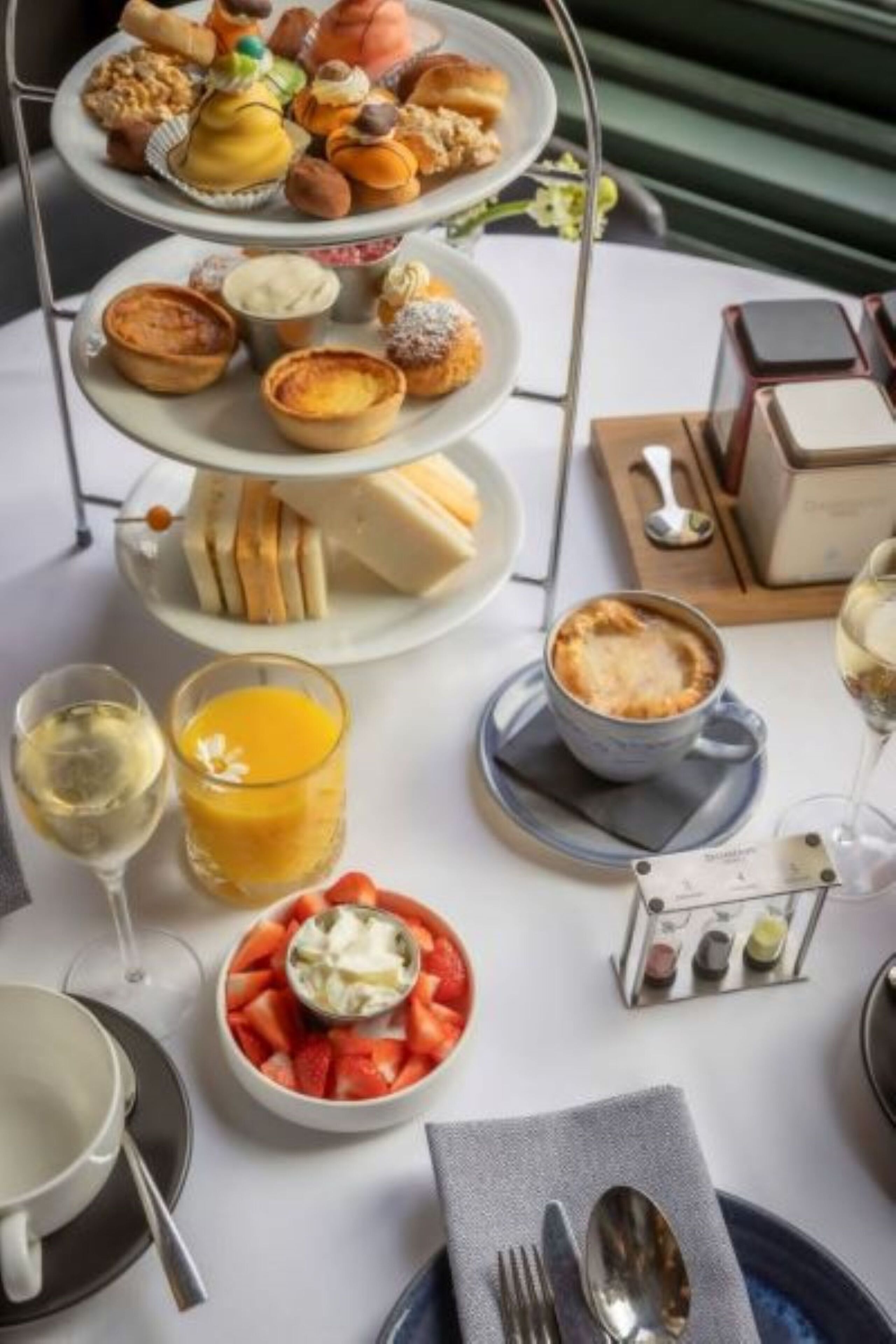 A breakfast buffet with various pastries, a fruit bowl, and a coffee cup.