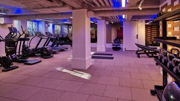 Een sportschool met loopbanden, elliptische trainers en gewichtbanken.