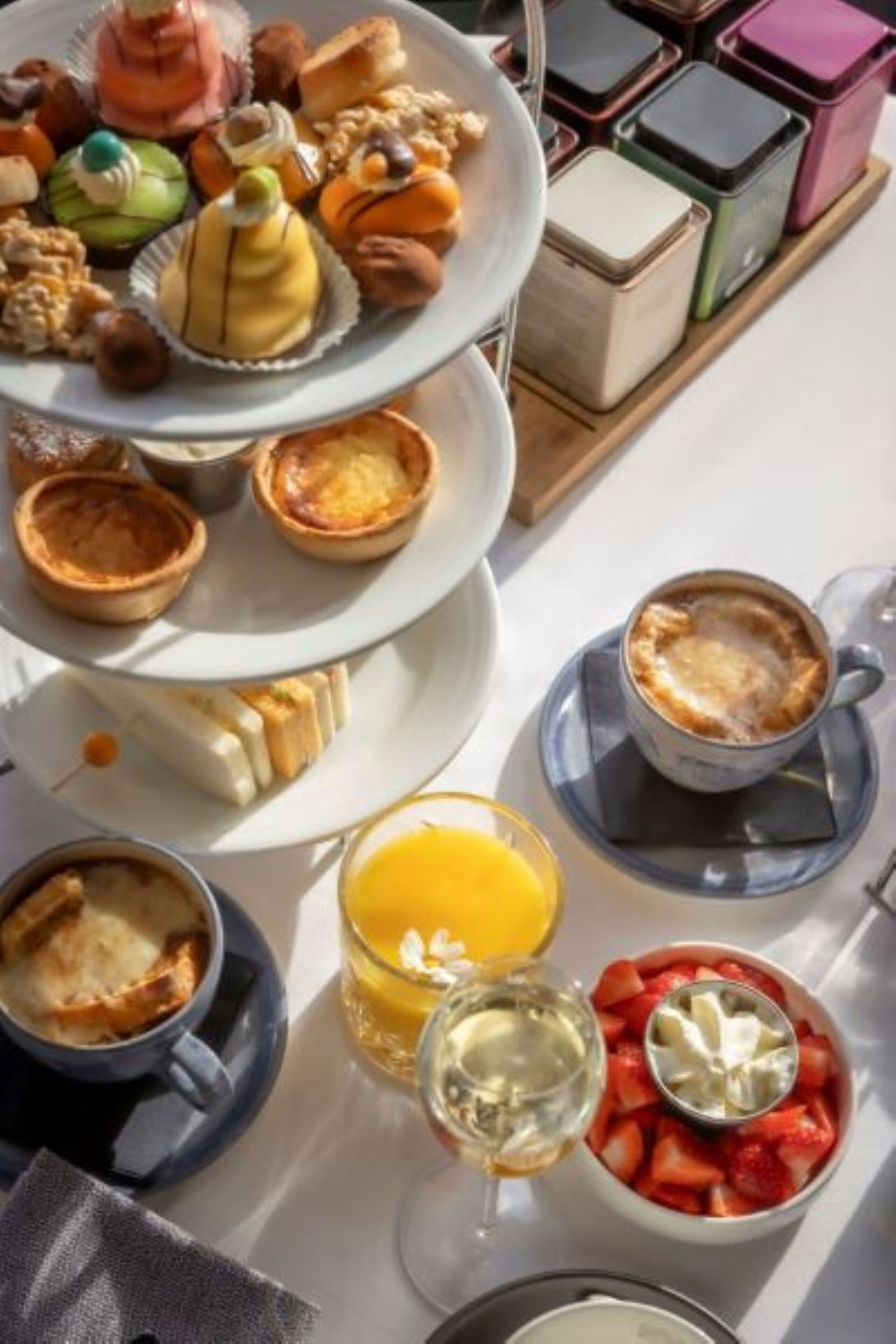 Desayuno con bollos, una taza de café y un vaso de jugo de naranja.
