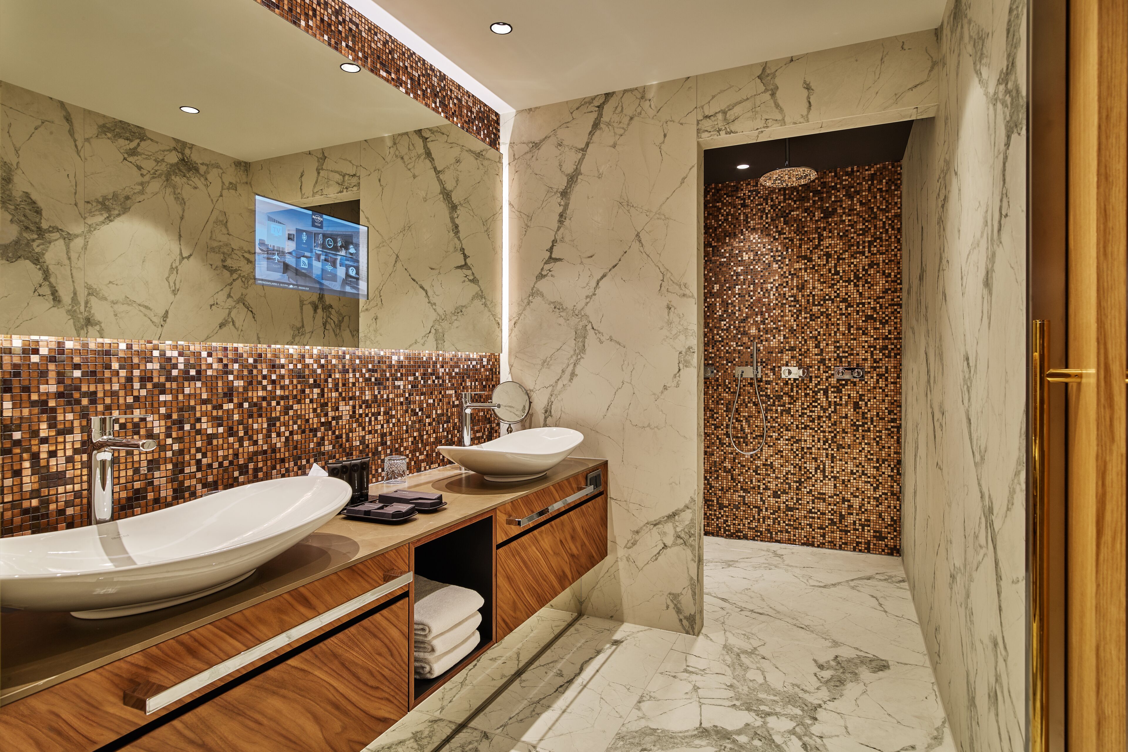 Un baño moderno con dos lavamanos, un mueble de tocador de madera y una zona de ducha con azulejos.