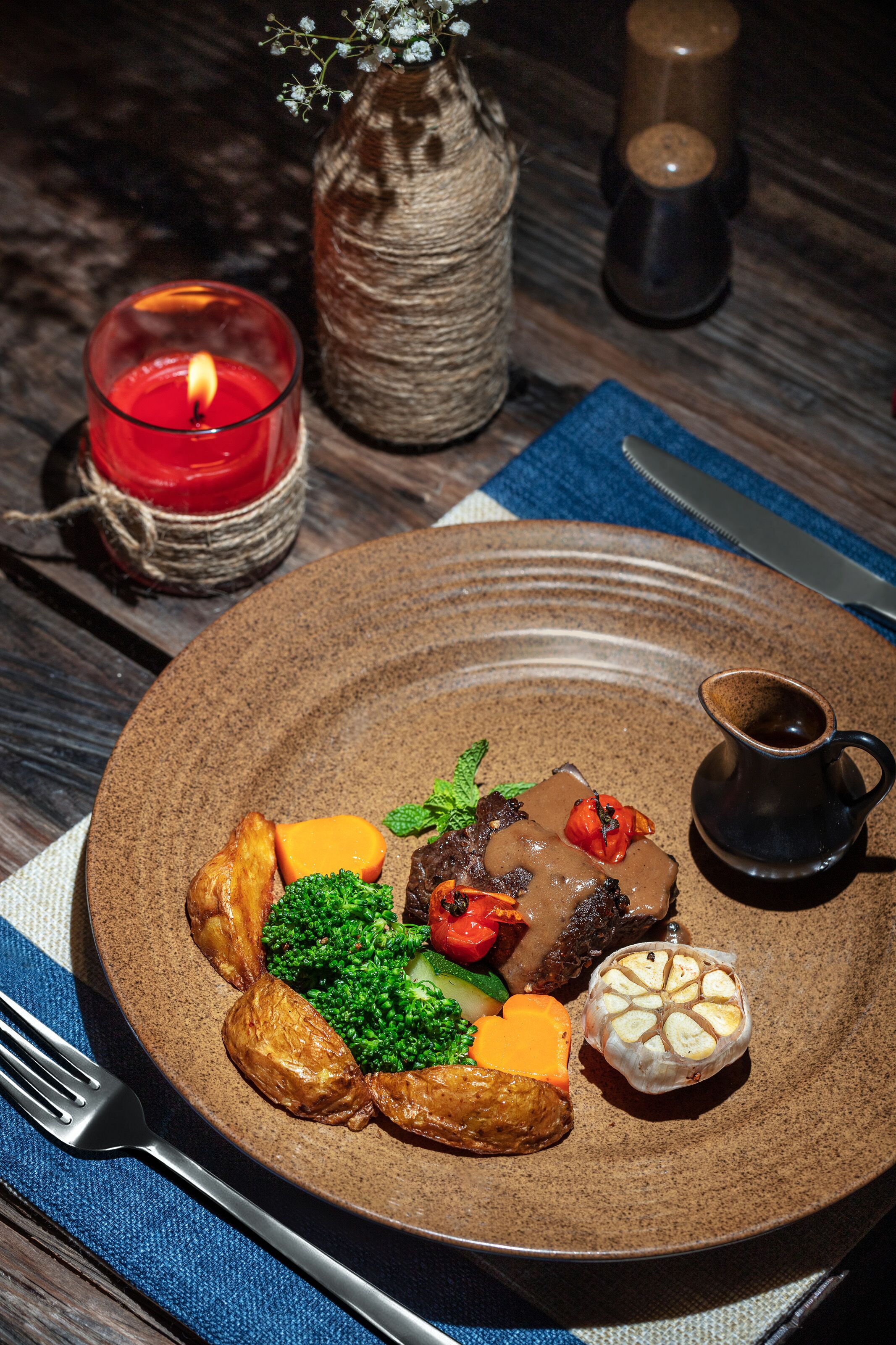 A plate of food with a variety of vegetables and a small jug.