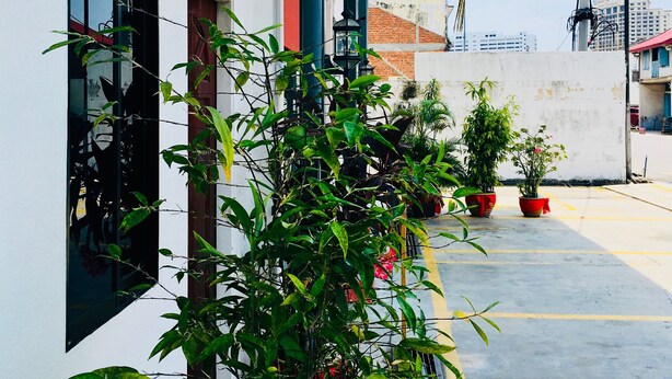 Un bâtiment doté d’un balcon, de plantes en pot et de lanternes rouges.