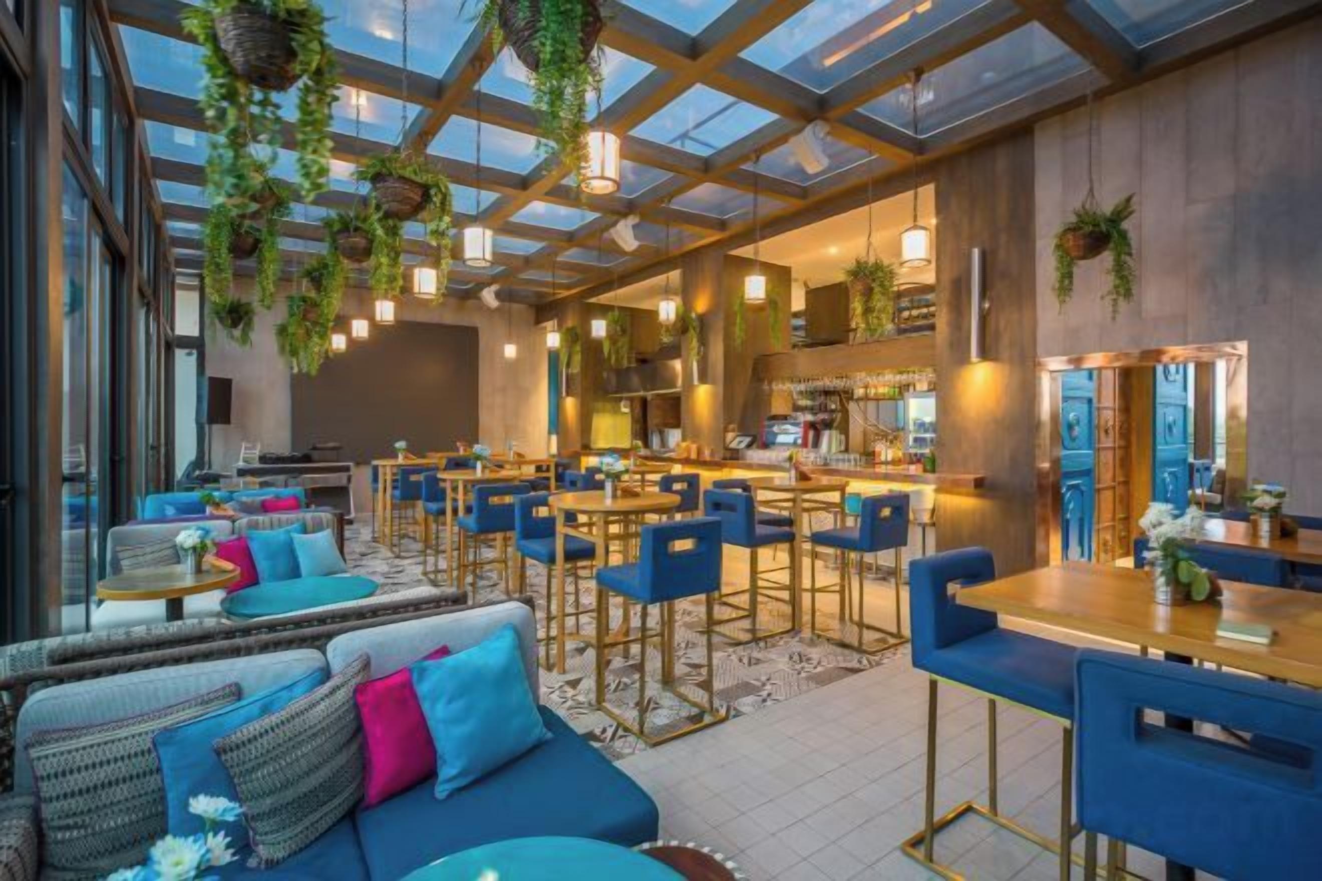 A modern interior with a bar area, seating arrangements, and a glass ceiling.