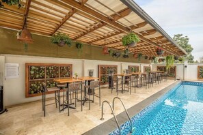 A poolside area with outdoor seating and a covered patio. - The Social House (Nairobi)
