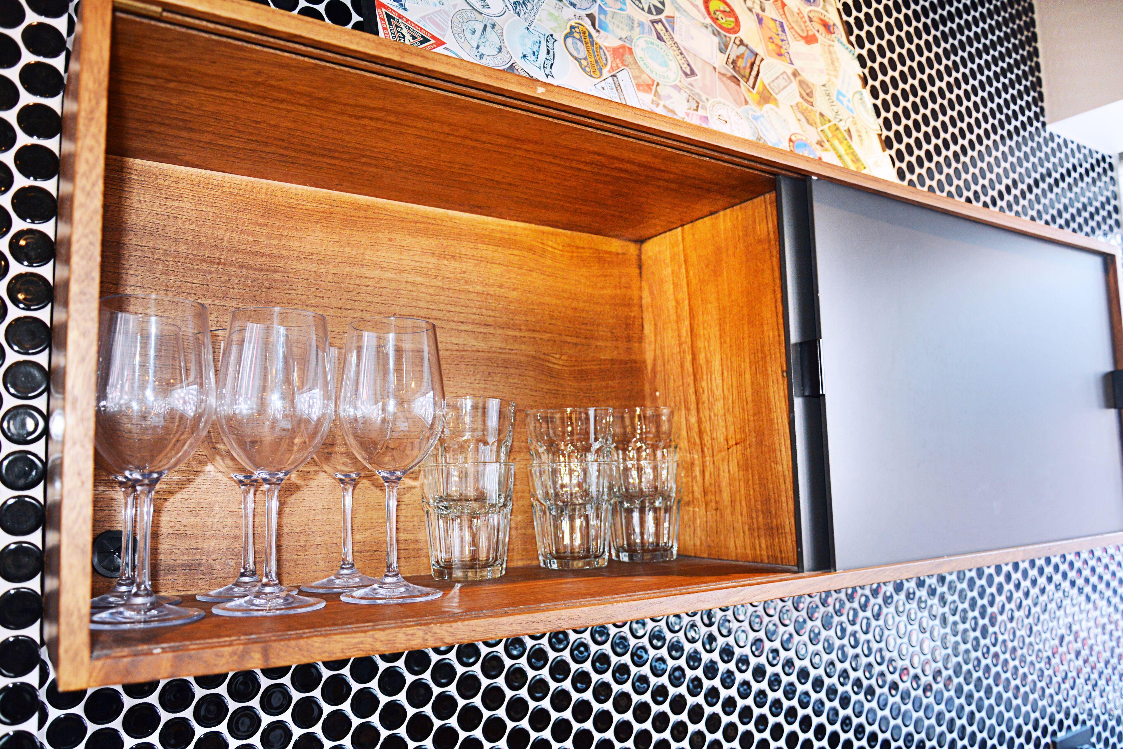 A wooden cabinet with a perforated metal panel design.