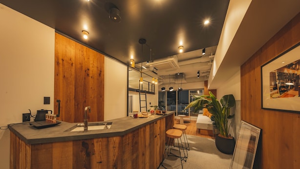 A modern kitchen with wooden accents, a bar area, and a large window providing natural light. - illi Sun Shimokitazawa (Tokyo)