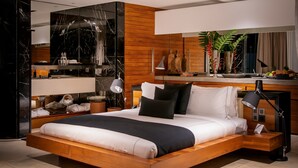 A modern bedroom with a wooden bed, a vanity with a mirror, and a desk with a lamp. - Haritha Villas & Spa (Hikkaduwa)