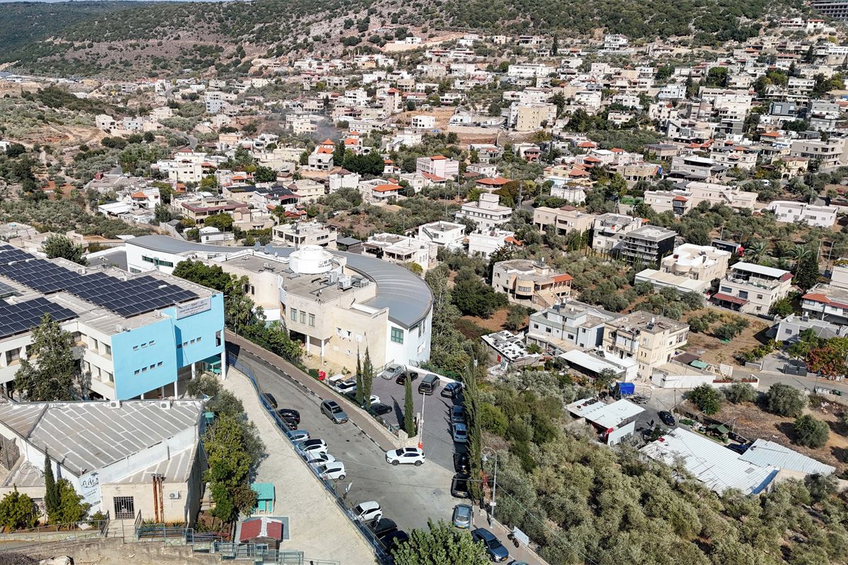A residential area with multiple buildings, a parking lot, and a road.