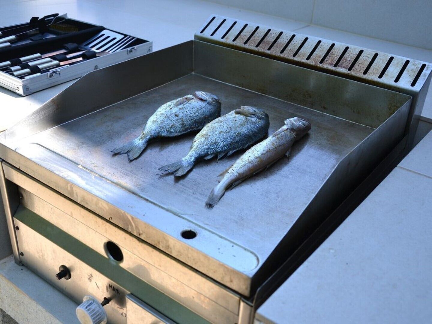 A grill with three fish on it.