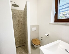 Une salle de bain avec une douche, des toilettes et un lavabo.
