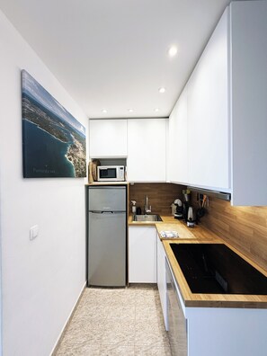 A modern kitchen with white cabinets, a stainless steel refrigerator, a microwave, and a wooden countertop. - Apartment 2 - two double rooms sea view terrace (apartment 2) (Punat)