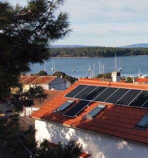 Un bâtiment situé sur la côte, doté d’un toit recouvert de tuiles rouges et de panneaux solaires.