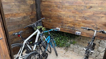 Een fietsenstalling met houten wanden en een grindvloer, geschikt voor 4 tot 5 fietsen.