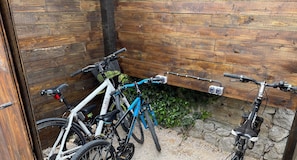 A bike storage area with wooden walls and a gravel floor, accommodating 4/5 bikes.