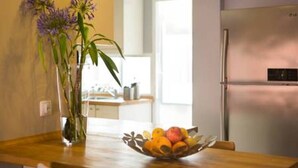 A kitchen with a wooden countertop, a bowl of fruit, and a refrigerator. - Peaceful Top Floor Apt W Balconies-Cambridge RIGHT (AC) (Funchal)