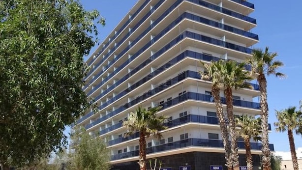 Un hotel de varios pisos con un diseño moderno, que cuenta con balcones en cada planta.