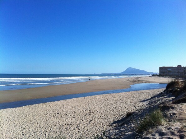 A beach with a large building in the background.