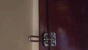A wooden door with a metal latch and a keyhole.