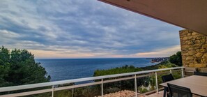 A balcony with a stone wall, overlooking a coastal view with the sea and distant land. - Large family villa with an exceptional view of the Calanques—sleeps 10 (Ensuès-la-Redonne)