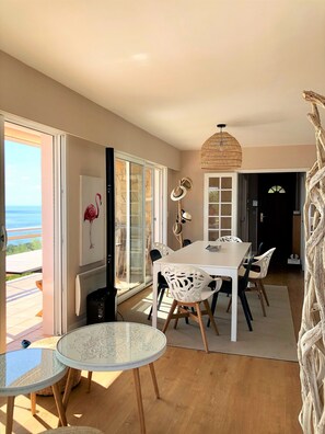 A dining area with a white table and chairs, a glass-top table, and a woven ceiling light fixture. - Large family villa with an exceptional view of the Calanques—sleeps 10 (Ensuès-la-Redonne)
