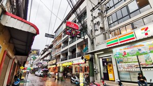 Une rue commerçante, où l’on trouve notamment un magasin 7-Eleven et un restaurant.