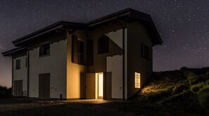 Vista frontal de la propiedad por la tarde o noche