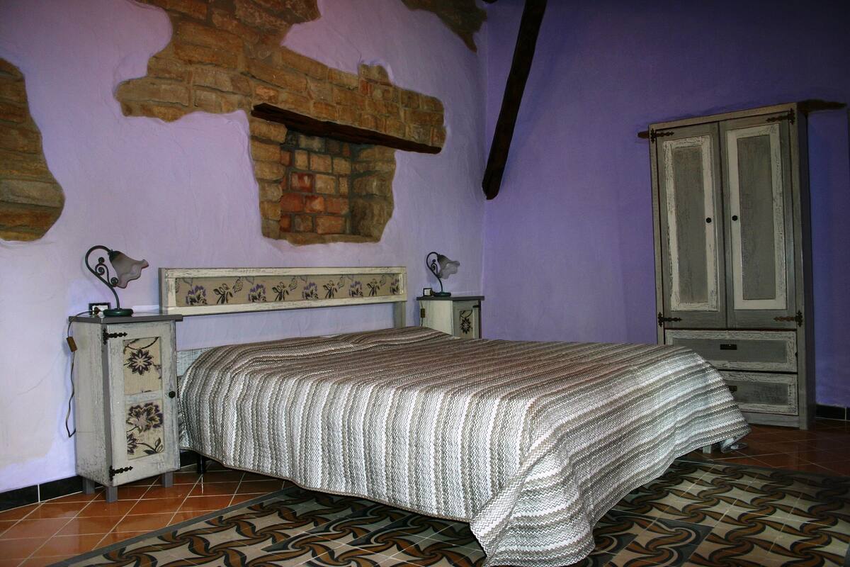 Ein Schlafzimmer mit einem Bett, einem Schminktisch, einem Spiegel und einer Ziegelwand.