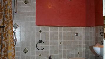 Un baño con dos inodoros, un lavamanos y una ducha.