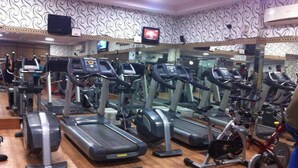 A gym with multiple treadmills, stationary bikes, and other fitness equipment. - Hotel Aerocity Golden (New Delhi)