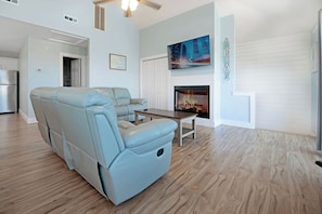 Una sala de estar con un sofá azul claro, una chimenea y un cuadro de un paisaje urbano en la pared.