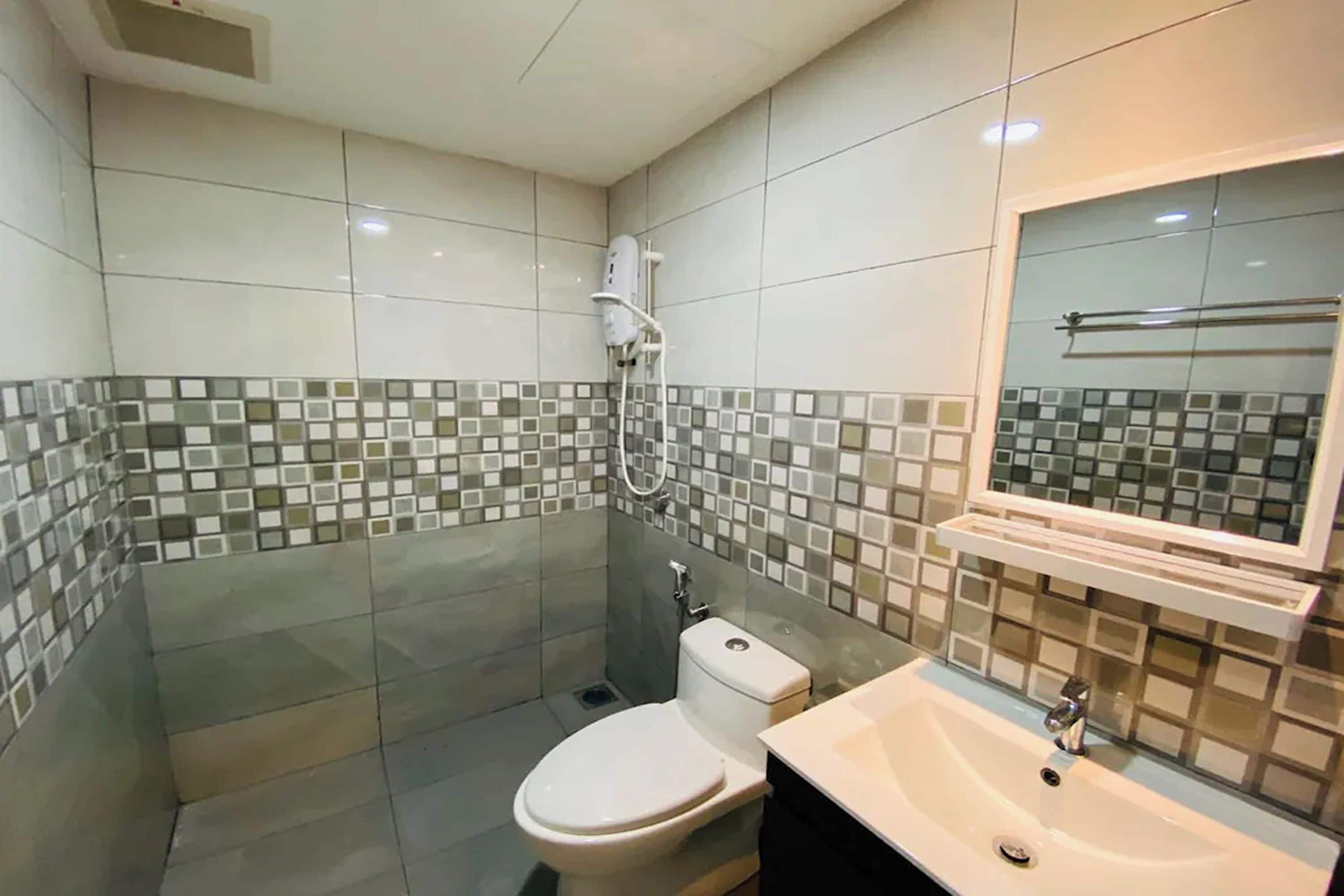 A modern bathroom with a toilet, sink, and shower.