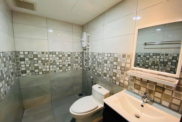 A modern bathroom with a toilet, sink, and shower.