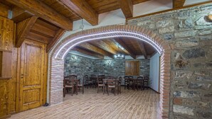 A rustic room with wooden floors, stone walls, and a wooden door. - Agriturismo Quercia Antica (Terranova di Pollino)