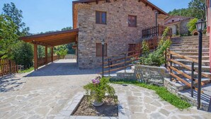 A stone building with a wooden staircase and a covered walkway. - Agriturismo Quercia Antica (Terranova di Pollino)