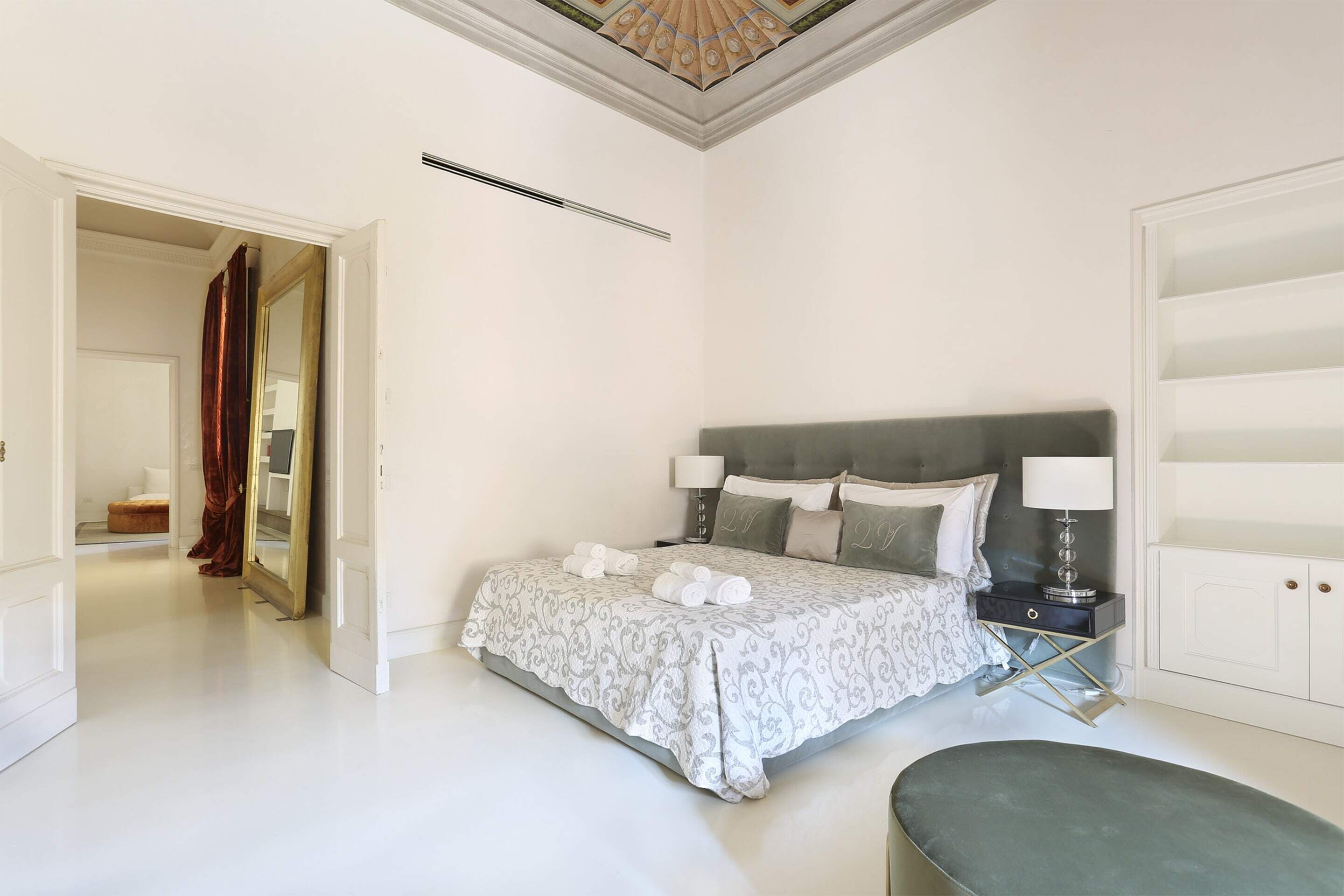 A bedroom with a bed, bedside tables, a nightstand, and a wardrobe.