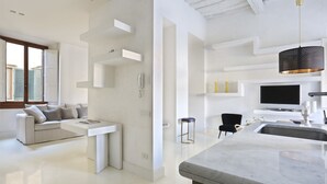A modern kitchen with a marble countertop and a hanging pendant light.