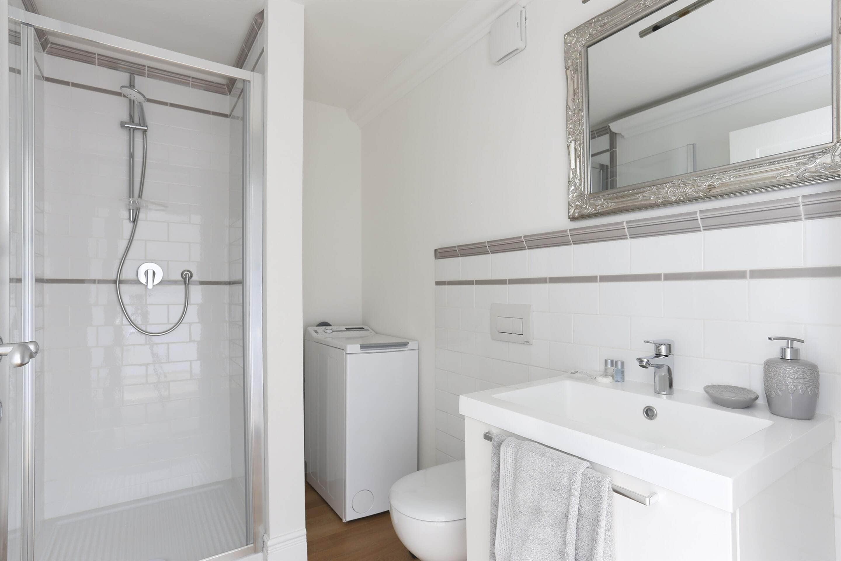 Une salle de bain moderne avec une douche à parois de verre, un lavabo blanc et des toilettes.
