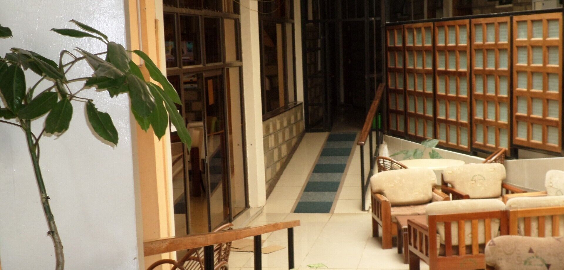 A hallway with a staircase, a bookshelf, and seating area.