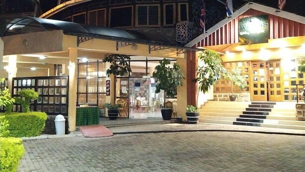 A hotel with a traditional architectural style, featuring a prominent entrance with steps and a covered area. - Vienna Woods Holiday Inn Limited (Nakuru)