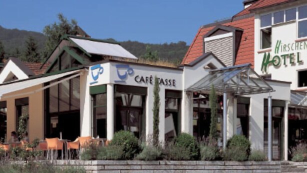 A café with outdoor seating and a hotel with a red roof. - Hotel beim Hirschen (Merzhausen)