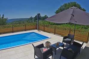 Een buitenzwembad en ligstoelen